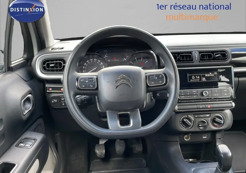 Vue intérieure centrée sur le volant et le tableau de bord gris noir de la Citroën C3 Société blanche de 2019.