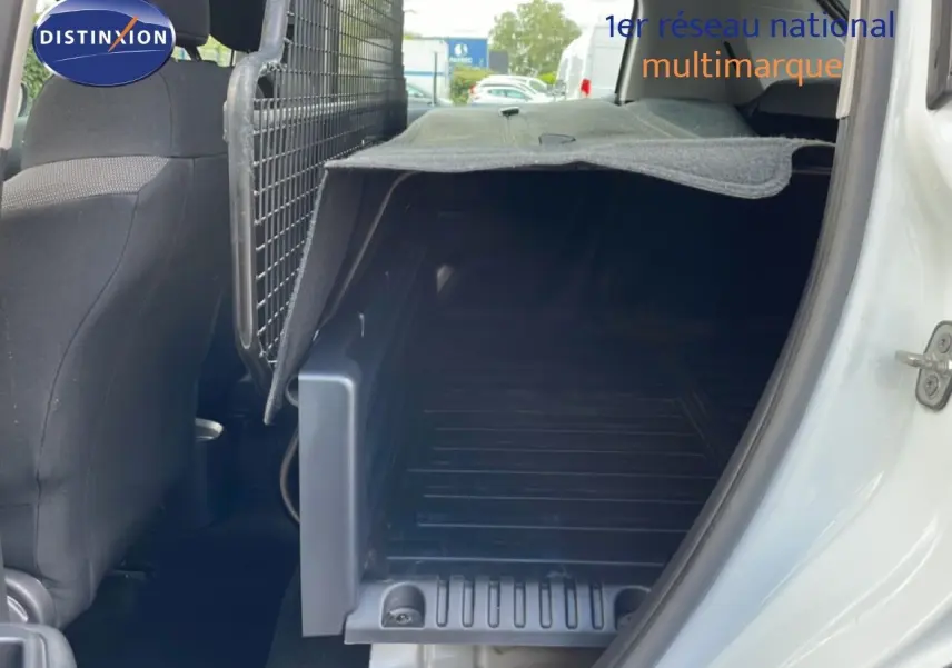 Vue intérieure côté droit du coffre utilitaire blanc banquise d'une Citroën C3 Société 2019 avec cloison métallique et tapis de protection.