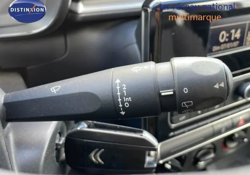 Gros plan sur la commande d’essuie-glace à gauche du volant dans l’habitacle d’une Citroën C3 Société blanc banquise.