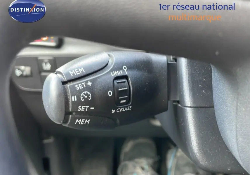 Gros plan sur la commande de régulateur de vitesse à gauche du volant d'une Citroën C3 Société blanc banquise.