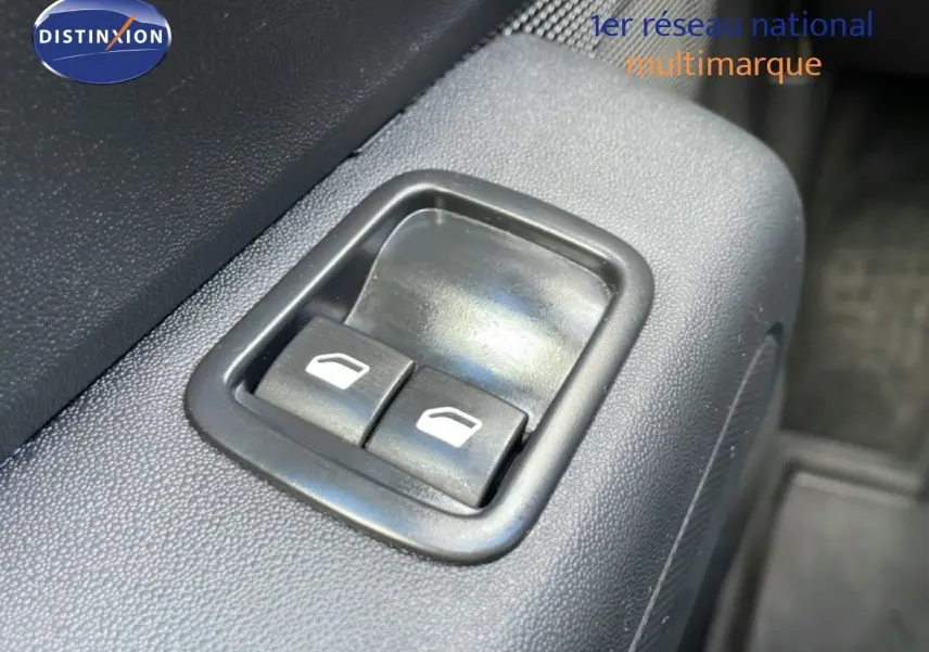 Gros plan sur les commandes de lève-vitres électriques côté conducteur d'une Citroën C3 Société blanche.