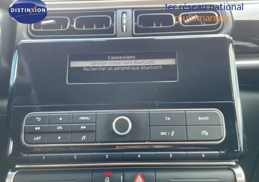 Vue rapprochée de la console centrale noire du Citroën C3 Société blanc banquise, affichant l'écran Bluetooth et les commandes radio.