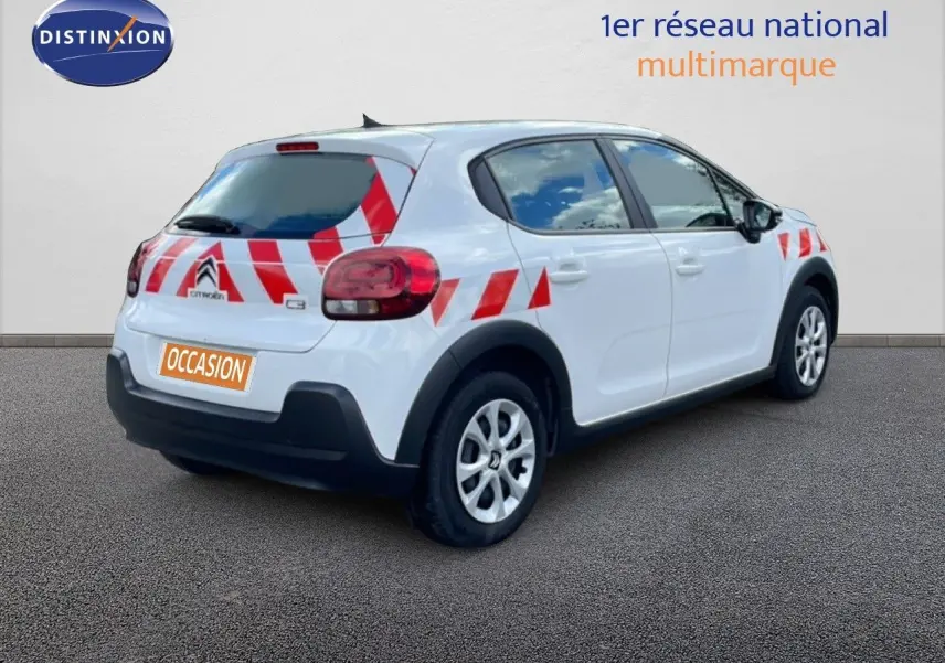 Vue 3/4 arrière droite d'une Citroën C3 Société blanche avec marquages rouges de sécurité sur la carrosserie.