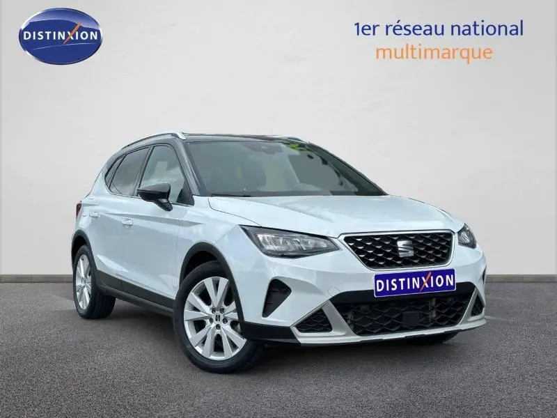 SEAT Arona blanc Nevada métal avec toit noir, vue 3/4 avant mettant en valeur la calandre et les jantes alu.