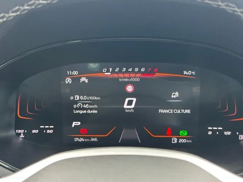 Vue rapprochée du tableau de bord numérique du SEAT Arona 2025, affichage clair avec fond noir et détails orange.
