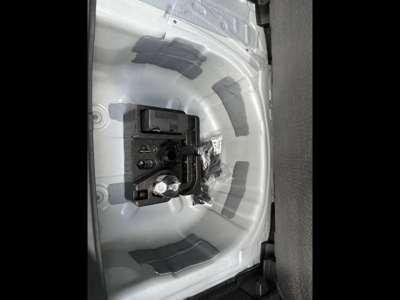 Vue en plongée sur le coffre du SEAT Arona 2025, montrant le rangement sous plancher gris clair sans roue de secours.