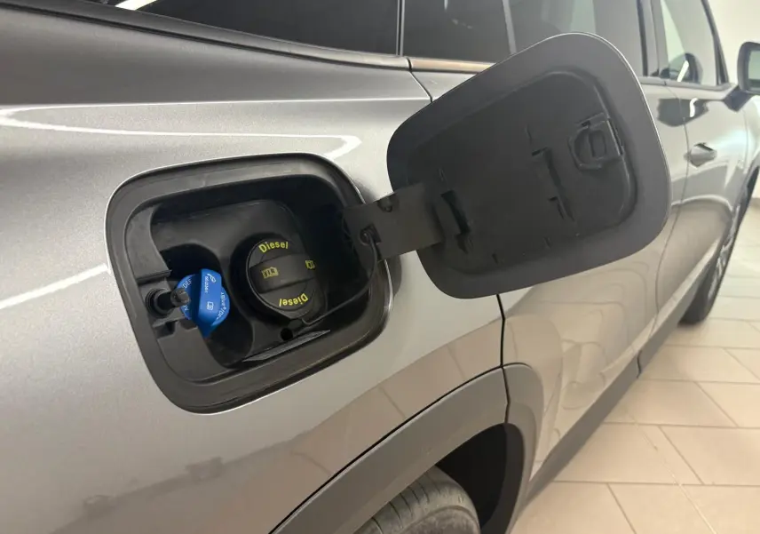 Vue de côté droit du Skoda Kodiaq gris graphite 2025, trappe à carburant ouverte montrant le bouchon diesel et AdBlue.