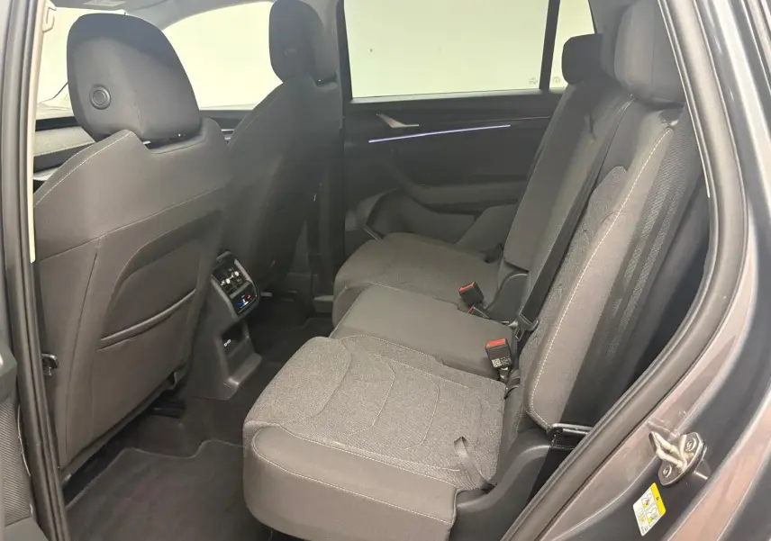 Vue intérieure côté droit des sièges arrière gris foncé du Skoda Kodiaq 2025 avec climatisation arrière et ceintures visibles.