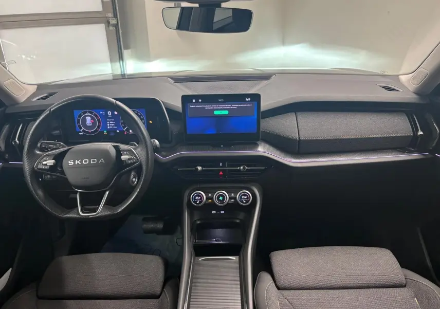 Vue intérieure frontale du Skoda Kodiaq 2025 gris graphite, mettant en valeur le tableau de bord numérique et l’écran tactile central.