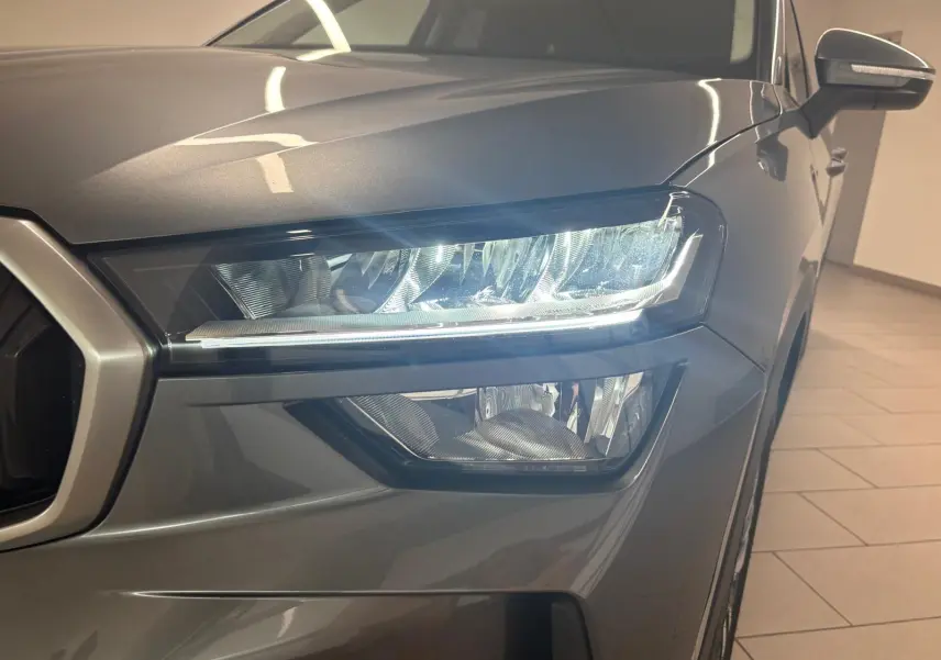 Gros plan sur le phare avant droit du Skoda Kodiaq gris graphite 2025, mettant en valeur son design moderne et précis.