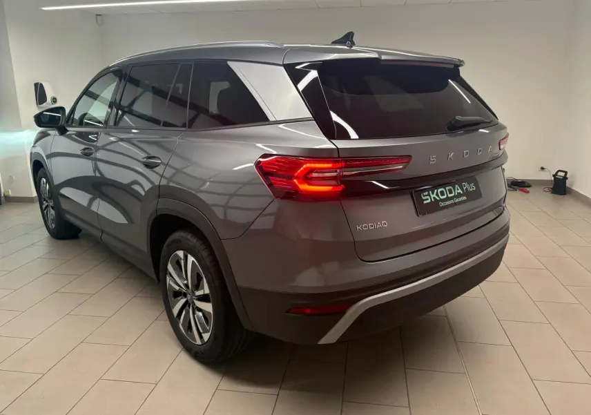Vue 3/4 arrière droite du Skoda Kodiaq gris graphite 2025 avec feux arrière allumés et jantes alliage.