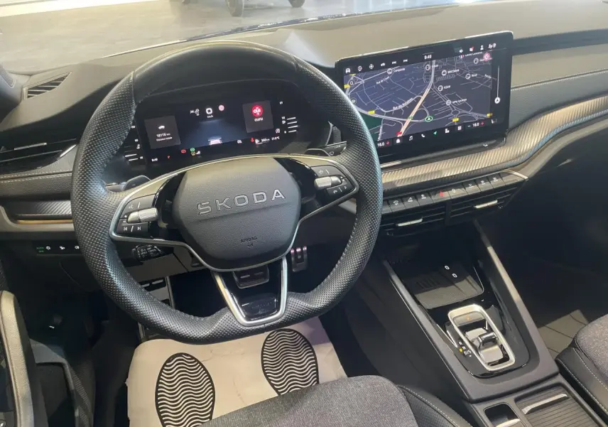 Intérieur Skoda Octavia 2025 vu de face, volant sport cuir, tableau de bord numérique et écran tactile GPS.