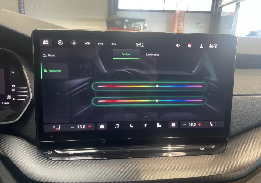 Écran tactile central du tableau de bord de la Skoda Octavia 2025, ambiance intérieure avec finition carbone.