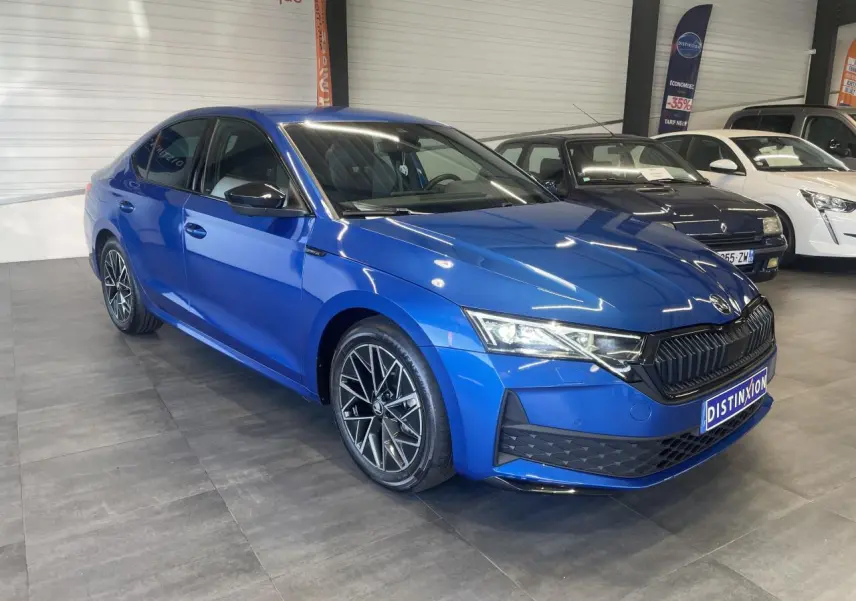 Vue 3/4 avant d'une Skoda Octavia 2025 bleu foncé avec jantes alliage noires et calandre noire sportive.