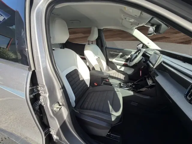 Vue intérieure côté conducteur de la Citroën C3 Aircross gris foncé, sièges bicolores noir et blanc, tableau de bord moderne.