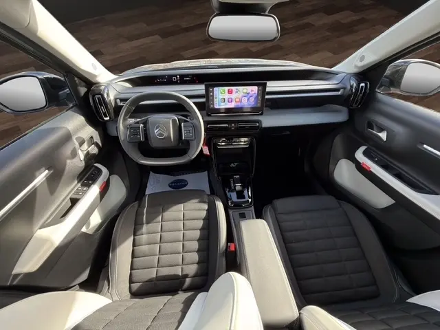 Vue intérieure avant de la Citroën C3 Aircross hybride 2025, tableau de bord moderne avec écran tactile central et volant multifonctions.