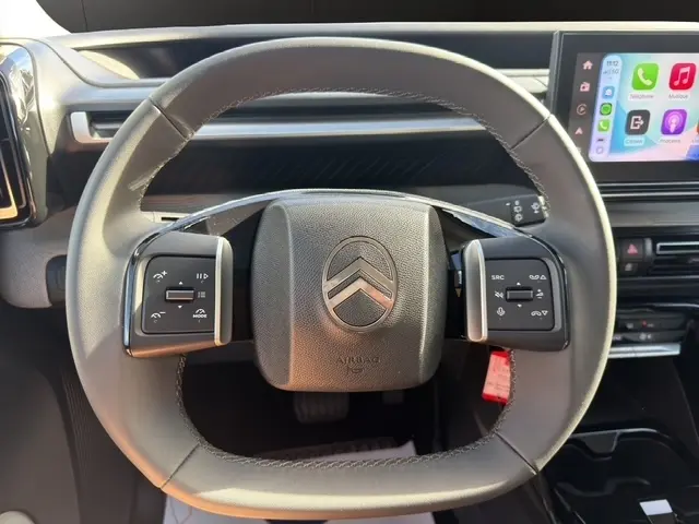 Vue rapprochée du volant cuir noir de la Citroën C3 Aircross 2025 avec commandes multifonctions et écran tactile visible à droite.