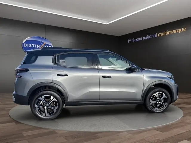 Profil droit du Citroën C3 Aircross hybride gris foncé 2025 avec jantes distinctives et barres de toit noires.