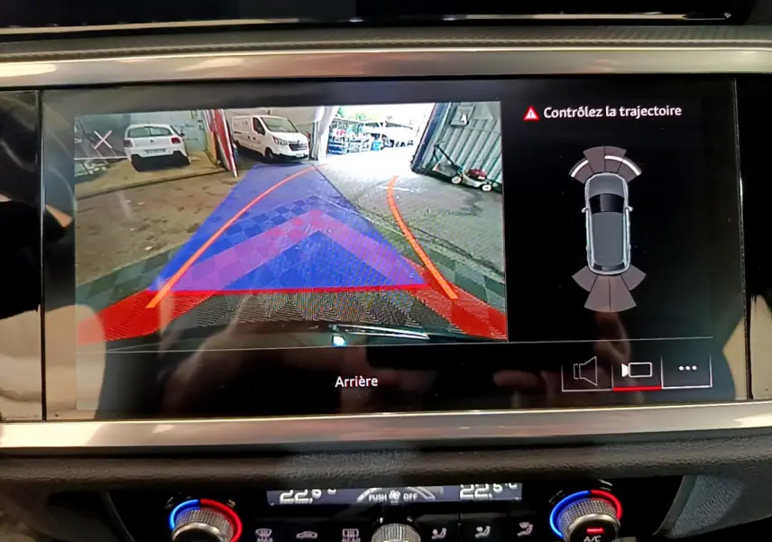 Écran tactile intérieur montrant la caméra de recul avec guidage et alertes sur un Audi Q3 noir de 2021.