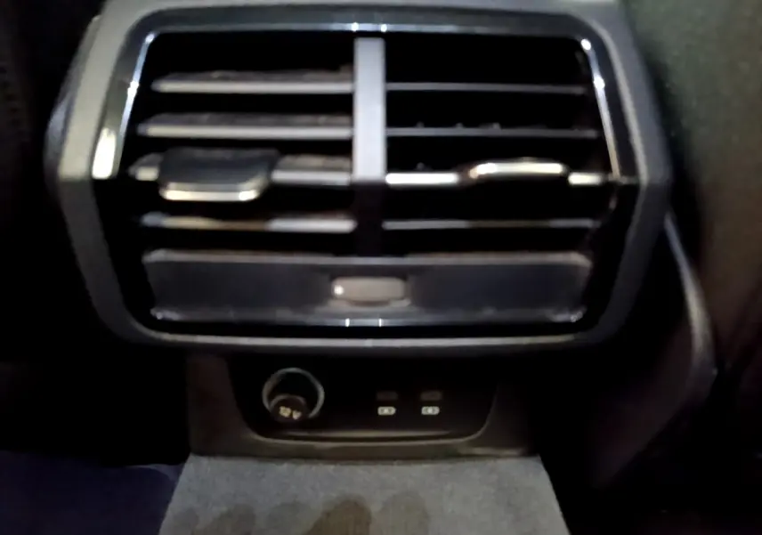 Vue rapprochée de la sortie d'air arrière noire avec prise 12V et ports USB dans un Audi Q3 35 TDI 2021.