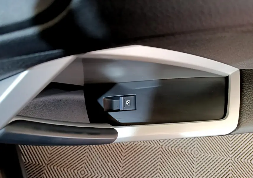 Gros plan sur la commande de lève-vitre côté conducteur de l'Audi Q3 35 TDI Business Line noire, intérieur moderne.