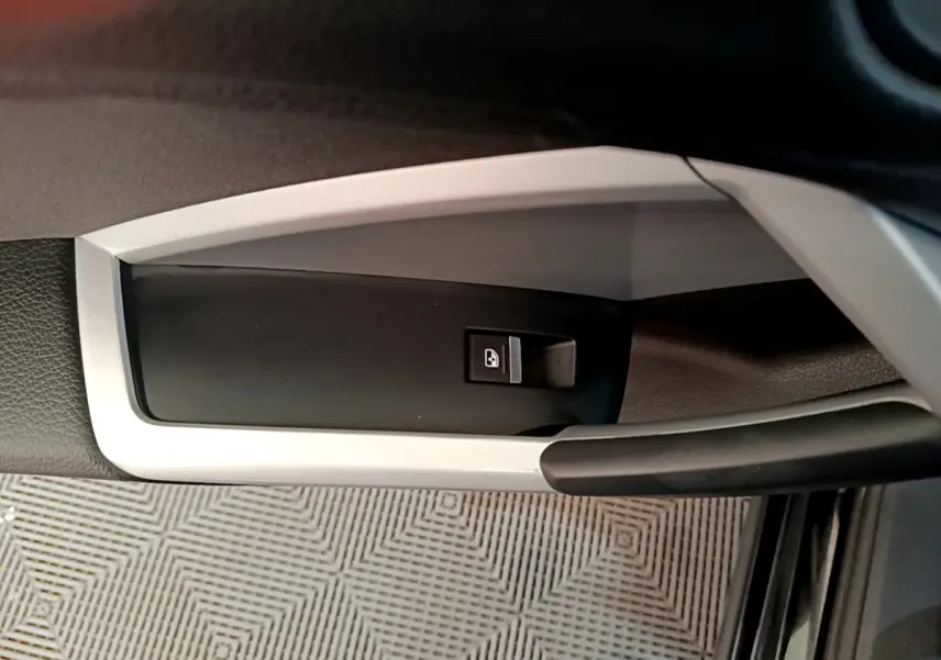 Gros plan sur la poignée intérieure de porte côté conducteur de l’Audi Q3 noir avec bouton de verrouillage centralisé.