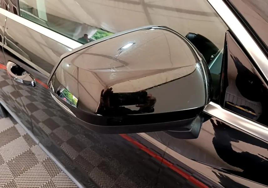 Rétroviseur côté conducteur noir brillant de l'Audi Q3 35 TDI 150 S tronic Business Line 2021, vue rapprochée.