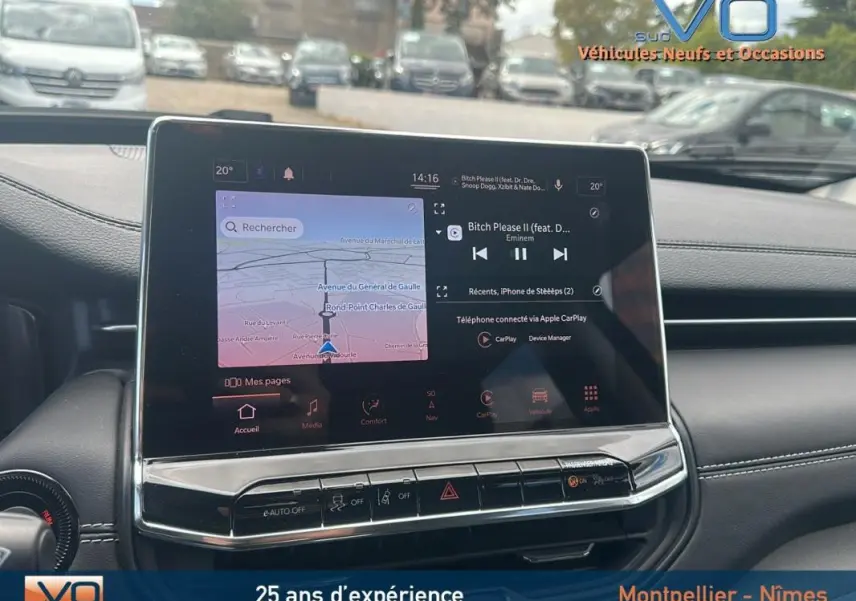 Écran tactile central du tableau de bord du Jeep Compass bleu 2023, affichant navigation et musique, vue intérieure frontale.