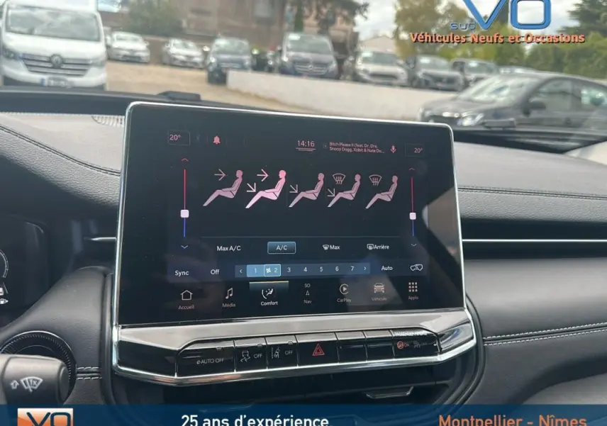 Vue rapprochée de l'écran tactile central du Jeep Compass bleu 2023, affichant les réglages de climatisation et confort.