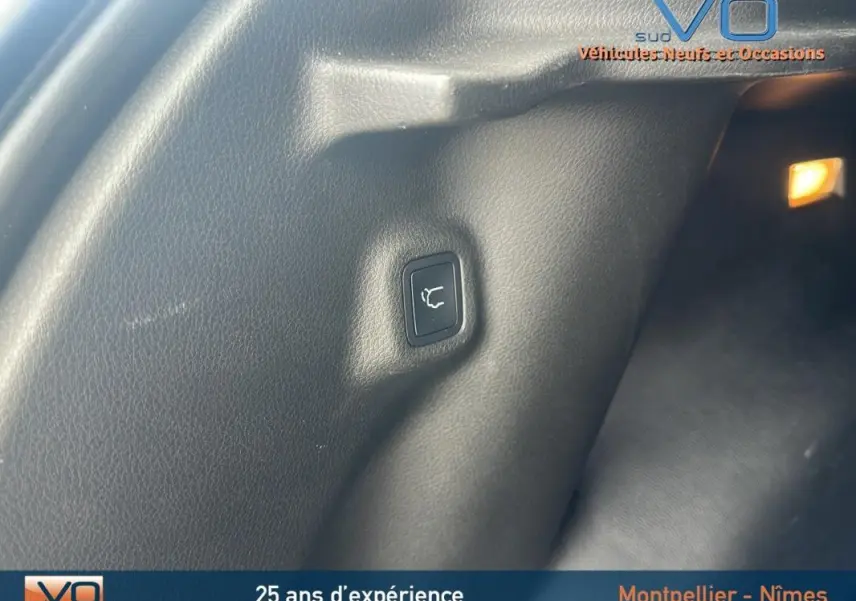 Bouton d'ouverture du hayon dans le coffre du Jeep Compass bleu 2023, vue intérieure côté droit.