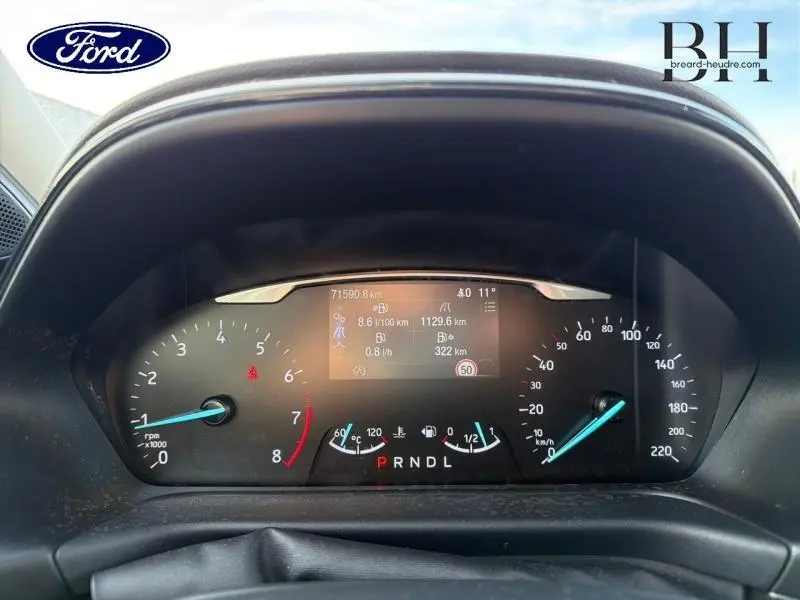 Vue rapprochée du tableau de bord numérique du Ford Puma gris, affichant compte-tours, vitesse et informations de conduite.