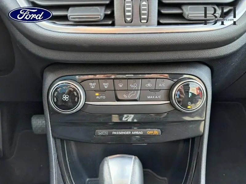 Vue rapprochée de la console centrale noire du Ford Puma 2020 avec commandes climatisation et indicateur airbag passager.