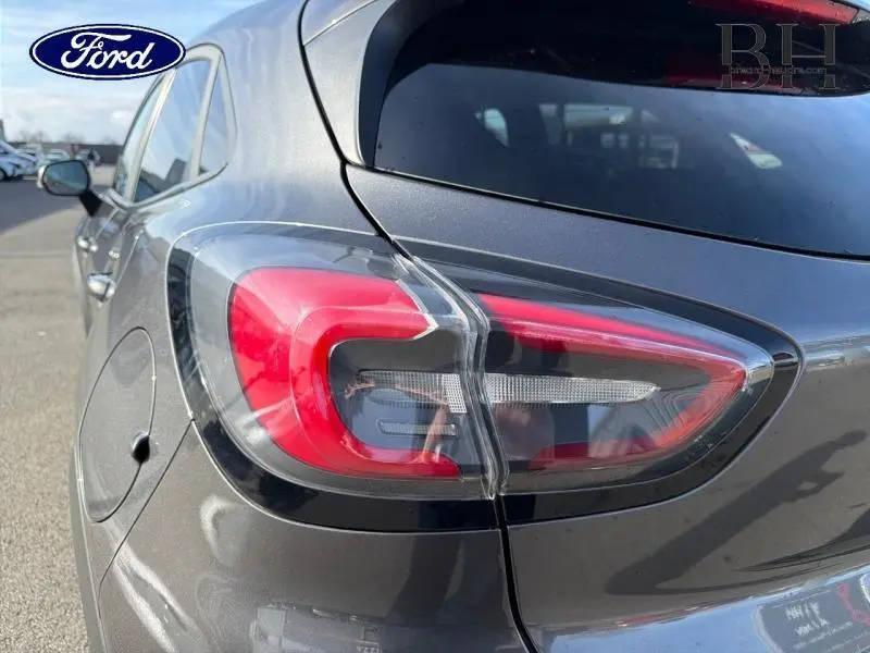 Gros plan sur le feu arrière droit d’un Ford Puma 2020 gris métallisé, soulignant ses lignes modernes et le reflet du ciel.