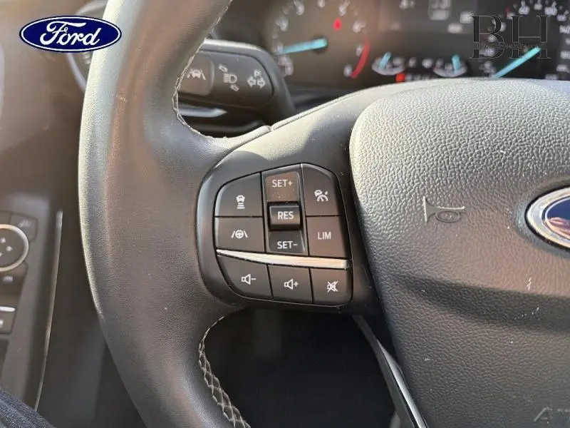 Gros plan sur les commandes multifonctions à gauche du volant cuir noir du Ford Puma 2020, détails des boutons visibles.