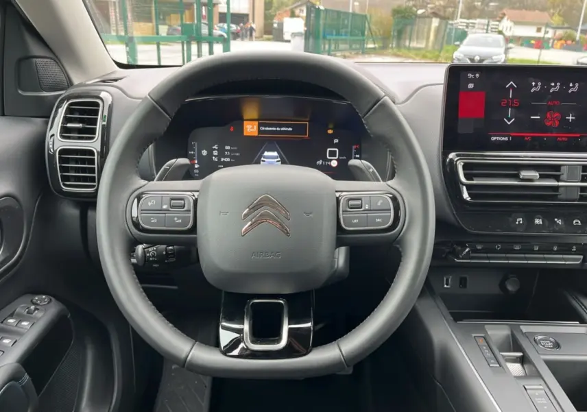 Vue frontale intérieure du volant cuir multifonctions et tableau de bord numérique du Citroën C5 Aircross Hybrid 2025.