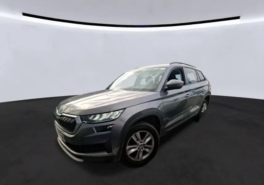 Vue 3/4 avant droit d'un Skoda Kodiaq gris 2023 avec jantes alu 17 pouces et calandre noire chromée.