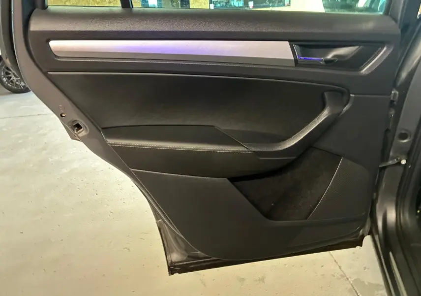 Porte arrière droite ouverte du Skoda Kodiaq gris 2023, intérieur noir avec insert aluminium brossé.