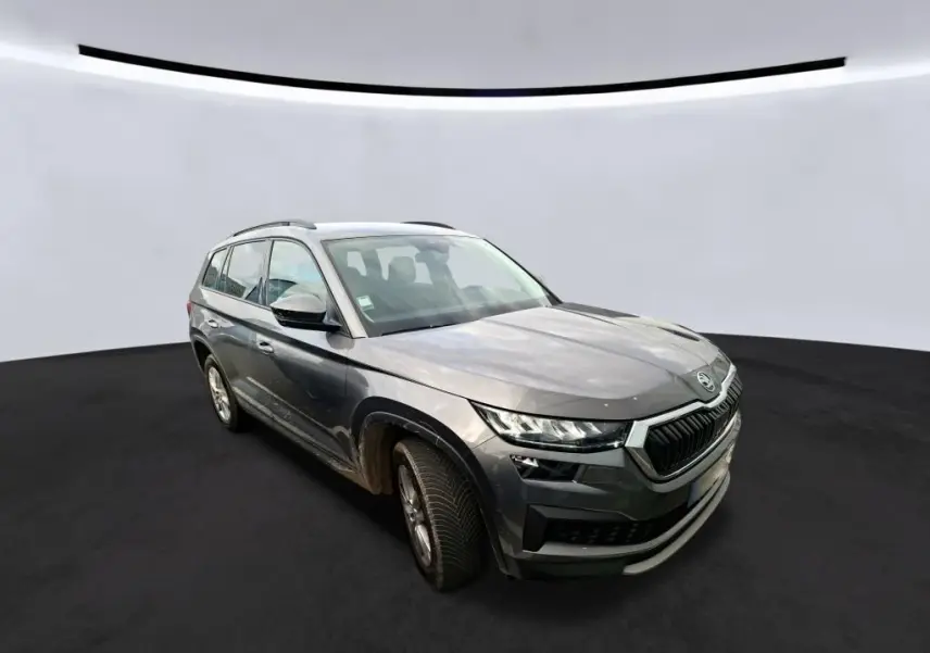 Vue 3/4 avant droit d'un Skoda Kodiaq gris 2023 avec calandre noire et jantes alu 17 pouces.