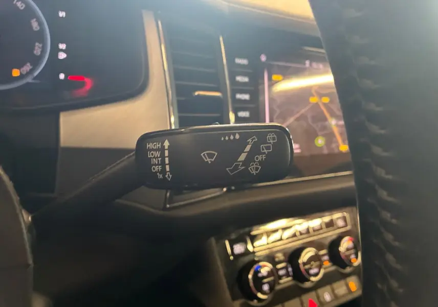 Gros plan sur la commande d’essuie-glace à gauche du volant dans l’habitacle du Skoda Kodiaq gris 2023.