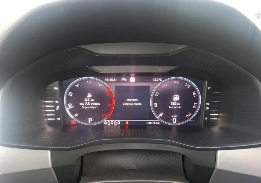 Tableau de bord numérique du Skoda Kodiaq gris, affichage de la vitesse, autonomie et alertes moteur.