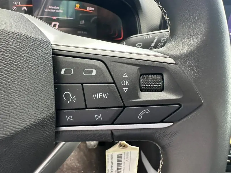 Gros plan sur les commandes multifonctions à droite du volant cuir du SEAT Arona 2025, boutons noirs avec marquages blancs.