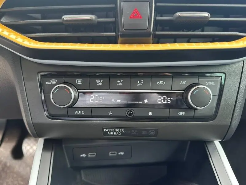 Gros plan sur la console centrale du SEAT Arona 2025, montrant la climatisation digitale et les commandes d’aération.