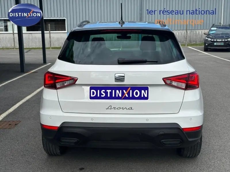 Vue arrière d'un SEAT Arona blanc Candy avec toit gris magnétique, feux arrière LED et double sortie d'échappement intégrée.