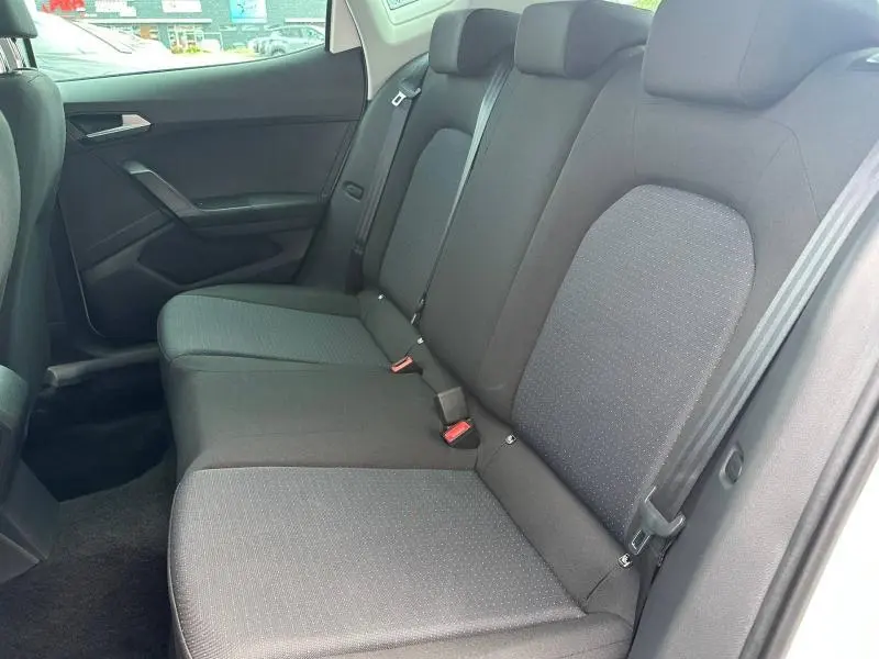 Vue latérale droite de la banquette arrière grise en tissu du SEAT Arona 2025, avec ceintures et appuie-têtes visibles.