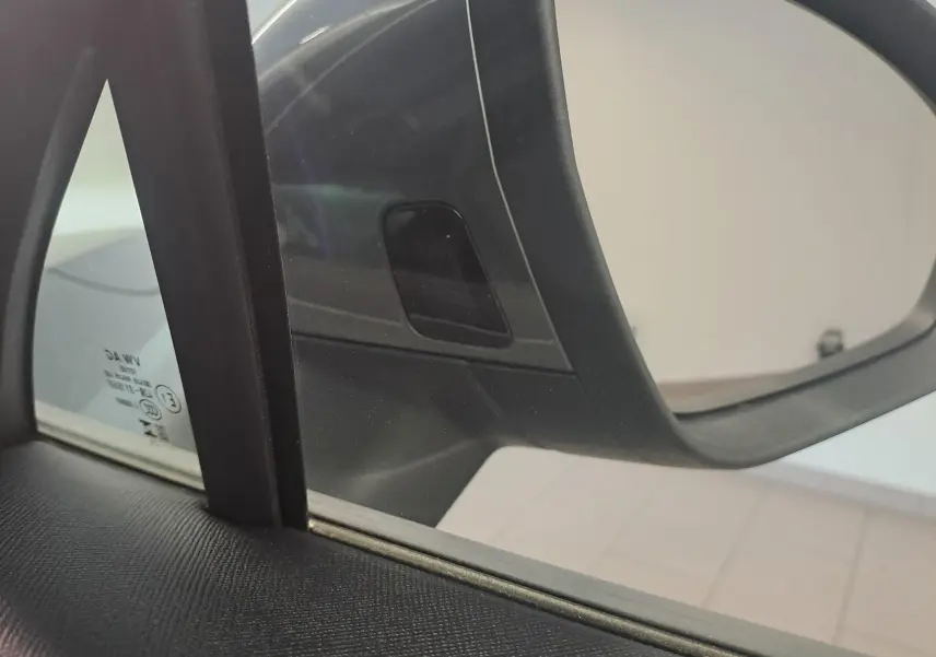 Gros plan sur le rétroviseur côté droit du Skoda Kodiaq gris graphite 2025, avec cadre noir intérieur visible.