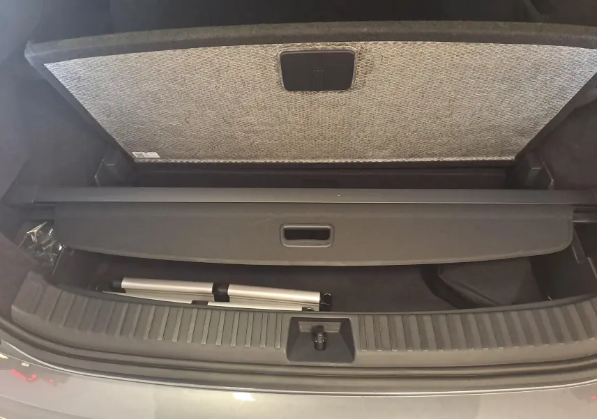Coffre ouvert du Skoda Kodiaq 2025 gris graphite, vue plongeante sur le compartiment avec cache-bagages et rangement inférieur.