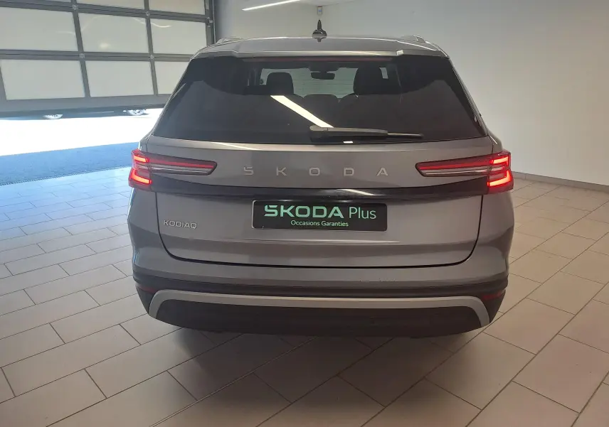 Vue arrière d'un Skoda Kodiaq gris graphite 2025 avec feux LED allumés, dans un garage éclairé.