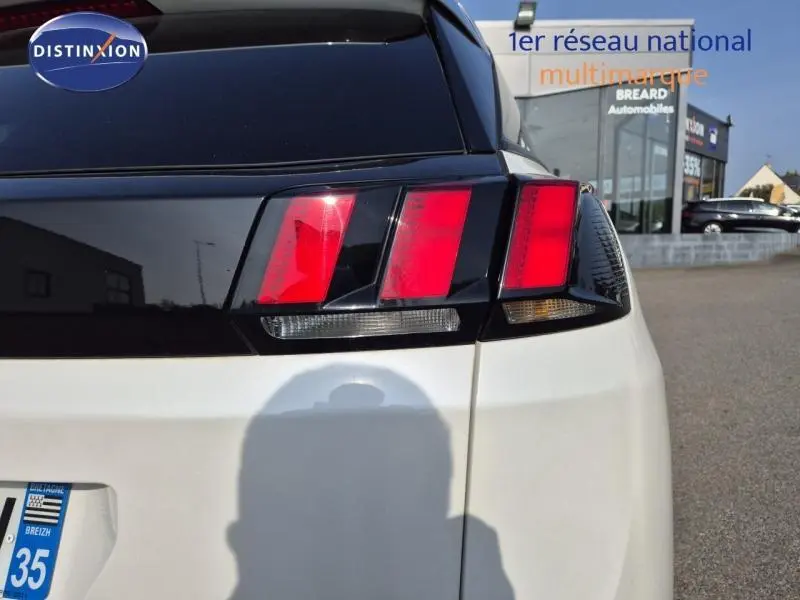 Gros plan sur le feu arrière droit d’un Peugeot 3008 blanc nacré, avec lunette arrière noire et logo Distinxion visible.
