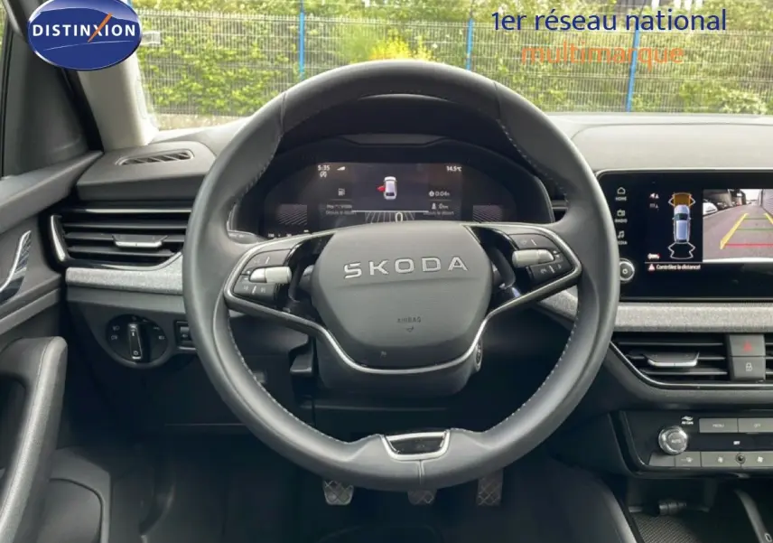 Vue centrée sur le volant cuir noir de la Skoda Scala blanc glacier avec tableau de bord digital et écran multimédia.
