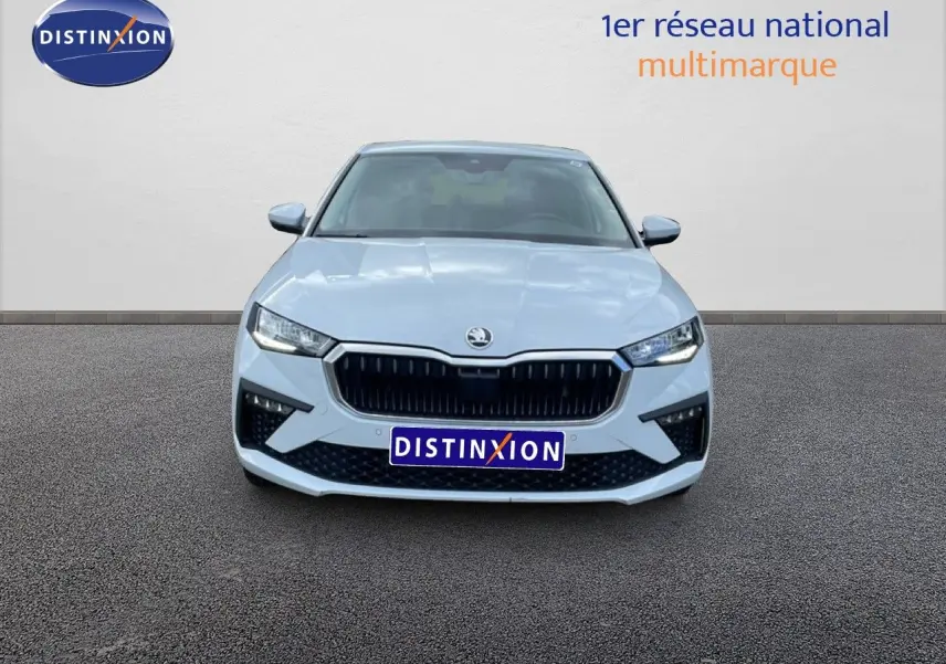 Vue frontale d'une Skoda Scala blanc glacier avec calandre noire et phares LED allumés sur fond neutre.